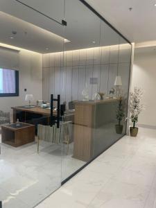 een kantoor met glazen wanden en een bureau en een stoel bij أركان نموذجية in Riyad +9 foto's