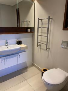 a bathroom with a white toilet and a sink at Zimbali Suites 108 in Ballito