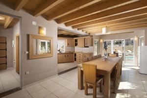 kuchnia z drewnianym stołem i jadalnią w obiekcie 6-bedroom Villa Chiara with Sea View w mieście Premantura
