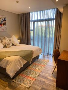 a bedroom with a bed and a large window at Zimbali Suites 108 in Ballito