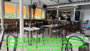 a restaurant with tables and chairs in a room at Valmas Village Apartments pool&bar in Skiathos