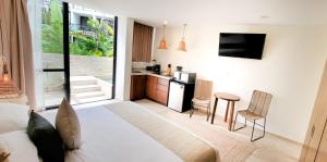 a living room with a bed and a kitchen at The Waves Tulum Intimate studio apartment with private plunge pool in Tulum