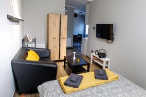 a living room with a black leather couch and a television at Apartman833 in Subotica
