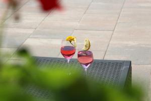 two wine glasses on a table with a flower in them at Pension Wirt am Bach in Terento