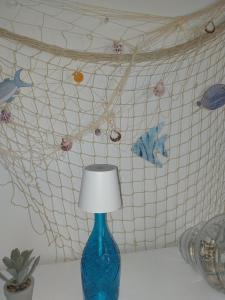a blue vase sitting on a table with a lamp at Villa Ornella in Luni +24 photos