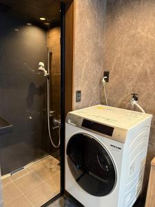 a washing machine in a bathroom with a shower at EKVOLI ROPPONGI TOKYO, Private Hotel in Tokyo +51 photos