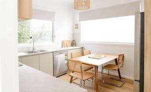 a kitchen with a table and chairs and a sink at Darcys cottage in Port Campbell