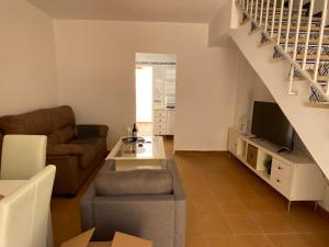a living room with a couch and a tv at BRISA del MAR in Isla Cristina