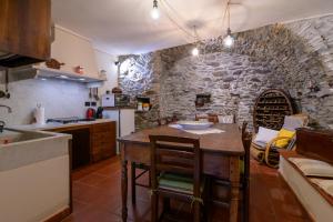 een keuken met een tafel en een stenen muur bij Taverna delle Mura in Ameglia