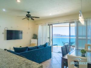 - un salon avec un canapé bleu et une vue sur l'océan dans l'établissement Playa Blanca Premier Unit 1104, à Isla Venado