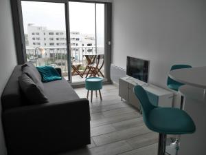 a living room with a couch and a table at La Grande Motte by la Paillère in La Grande Motte