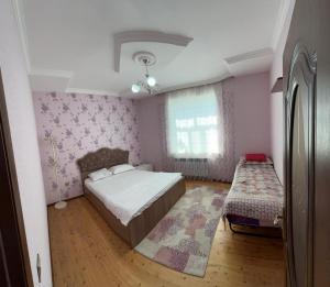 a small bedroom with a bed and a window at Yeşil Ev in Gabala +5 photos