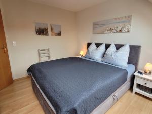a bedroom with a large blue bed with pillows at Fewo Büsum in Büsum +20 photos