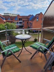 a table and two chairs and a bottle of wine on a balcony at Fewo Büsum in Büsum