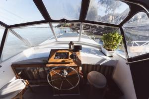 a boat with a wheel in the middle of the water at Volenter Lux Apartment Duna Boat in Baja