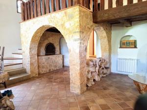 Duży pokój z kamienną ścianą i schodami w obiekcie Villa provençale avec piscine et jardin privé w mieście Saint-Cézaire-sur-Siagne
