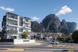 a building with a mountain in the background at Meteoron Suites in Kalabaka