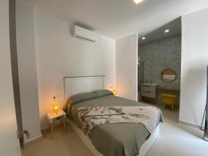 Un dormitorio con una cama y dos lámparas sobre una mesa. en Sol Sherry, en Jerez de la Frontera