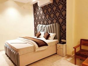 a bedroom with a large bed with a headboard at Hotel Manish Mansion in Lumbini