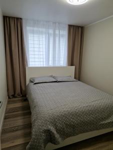 Кровать или кровати в номере Apartamentai Grigiškes
