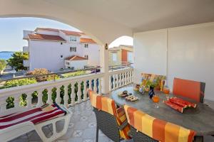 a balcony with a table and chairs and a view of the ocean at Spacious Terrace Apartments in Rogoznica