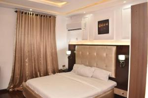 AgegeDEL HOTEL and SUITES的房间里有一张白色大床的卧室