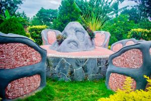 a statue of a head sitting on a table with two chairs at Amani home in Nkunjila