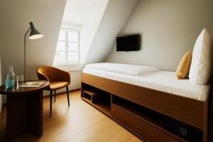 a bedroom with a bed and a table and a chair at Südspeicher in Kappeln