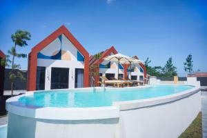 a large swimming pool in front of a building at Treehita Cabin Jogja in Sleman