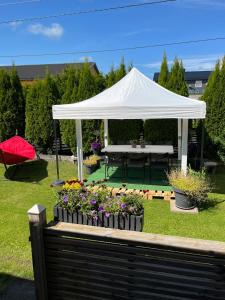 a white gazebo with a picnic table and flowers at Villa chaimae in Lii