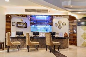 a hotel lobby with a bar with chairs at Akshaya Aura in Bengaluru