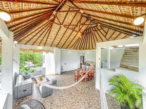 Una sala de estar abierta con techo de paja en Casa Solaje - Modern Costal house 5 min from Zica, en Puerto Escondido