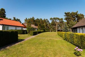 a walkway through a yard with bushes and houses at Holiday home Fuhlendorf 2 in Fuhlendorf