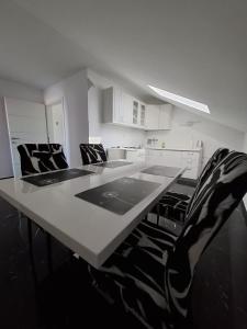 a table with black and white chairs in a kitchen at Sunshine apartments in Karlobag