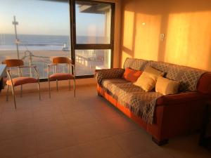 a living room with a couch and a large window at Ventanas al Mar in Villa Gesell