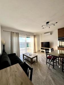 un soggiorno con un divano e un tavolo di Skyline Gozo Penthouse with Jacuzzi a Xagħra