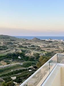 una vista sull'oceano dal balcone di una casa di Skyline Gozo Penthouse with Jacuzzi a Xagħra