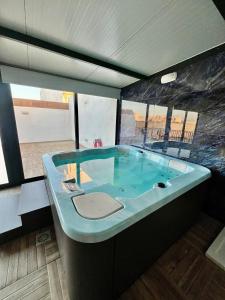una grande vasca da bagno blu in una stanza di Skyline Gozo Penthouse with Jacuzzi a Xagħra