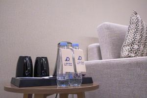 Una mesa con dos botellas de agua y vasos encima. en Daif Inn Serviced Apartments - Al Naseem, en Riad