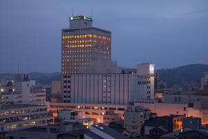 a tall building with lights on it in a city at ANA Holiday Inn Kanazawa Sky by IHG in Kanazawa