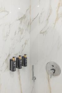 ein Bad mit weißen Marmorwänden und einer Dusche in der Unterkunft Vatican Pertusa Luxury Suites by Quinto Piano in Rom + 86 Fotos