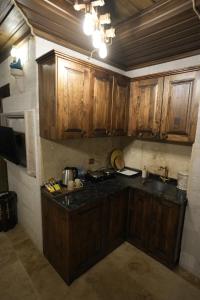 a kitchen with wooden cabinets and a counter top at Cevizli Konak in Uçhisar