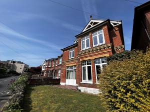 a red brick house with white windows on a street at Briar Bank in Shanklin