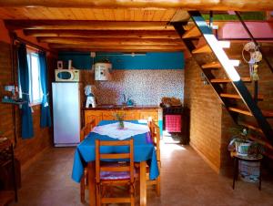 a kitchen with a table and a kitchen with a refrigerator at Cabaña AmaNacer in San Esteban