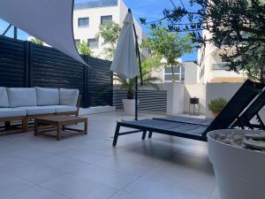 eine Terrasse mit einem Sofa, einem Tisch und einem Sonnenschirm in der Unterkunft Capitol Suites Exclusive in Zadar