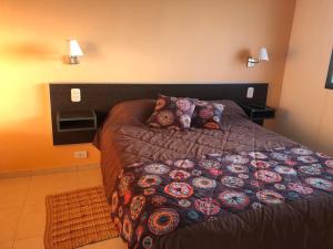 a bedroom with a bed with a blanket and pillows at Ventanas al Mar in Villa Gesell