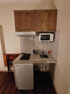 a small kitchen with a sink and a microwave at Résidence Molière Hôtel Paris Montrouge in Montrouge +17 photos