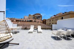a group of chairs sitting on top of a roof at Charming Apartment in the Heart of Málaga in Málaga