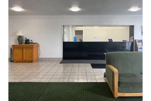 a waiting room with a chair and a counter at Studio 6 Suites Pocomoke City, MD in Pocomoke City