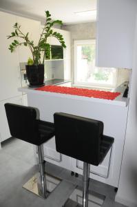 ソポトにあるSłoneczny apartament w Sopocieのキッチン(カウンター、黒い椅子2脚付)